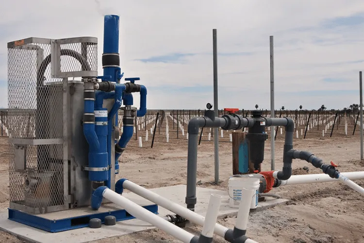 Fotografía de estructura color gris a lado de tubos color azul y gris que son parte de equipos de tratamiento de agua.