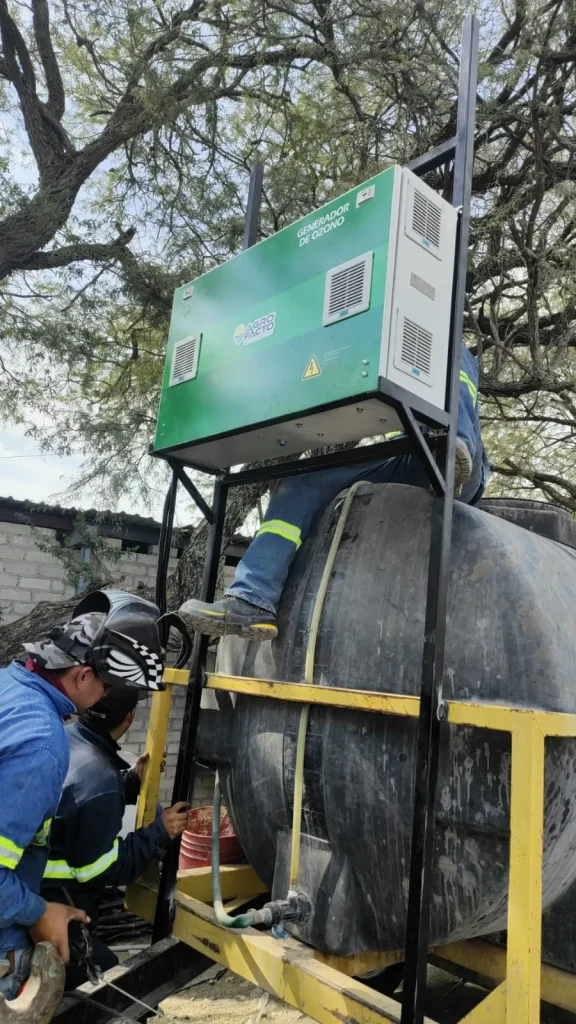 Fotografía desde abajo de personal profesional realizando la instalación de un tratamiento con ozono.